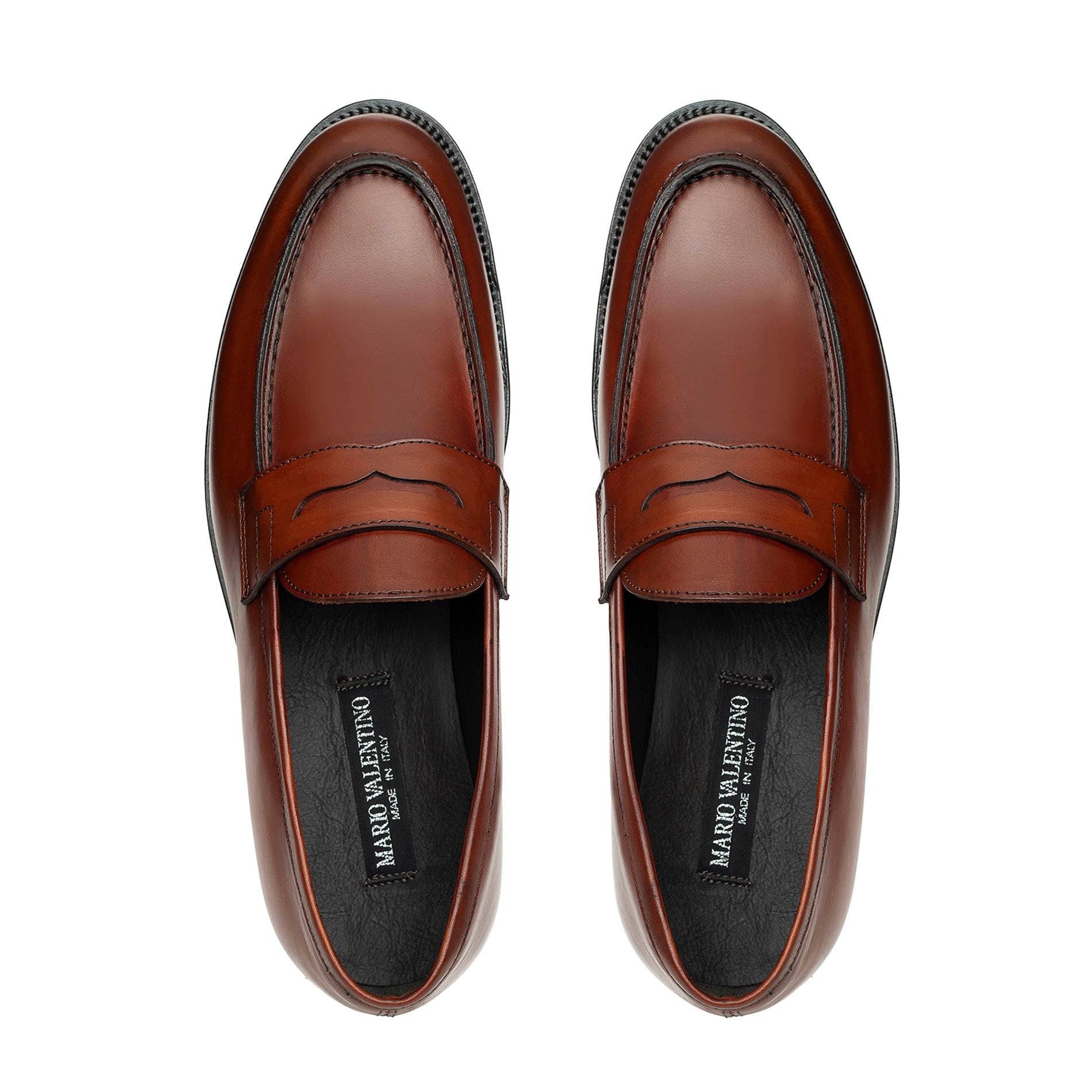 Top view of light brown leather penny loafers with saddle strap