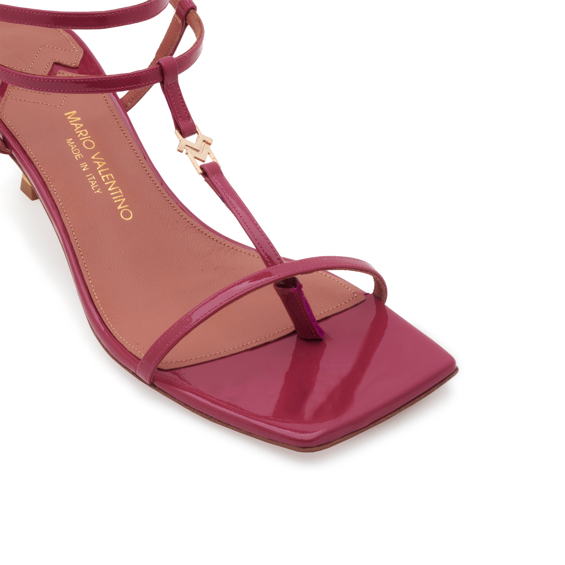 Detail of Mario Valentino Valerie purple glossy leather sandal with T-bar, logo accessory, and square toe.