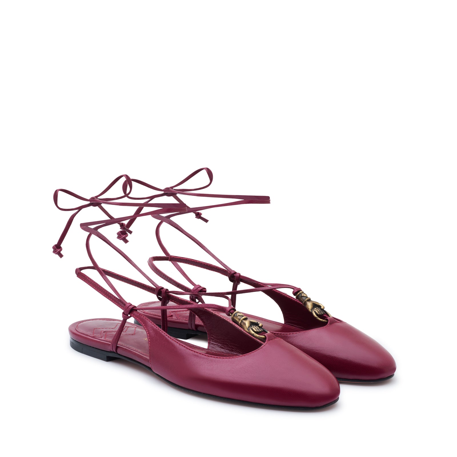 Mario Valentino elegant burgundy slingback ballet flats in kidskin leather, adorned with an ethnic-inspired gold-tone embellishment and delicate lace-up ankle tie.