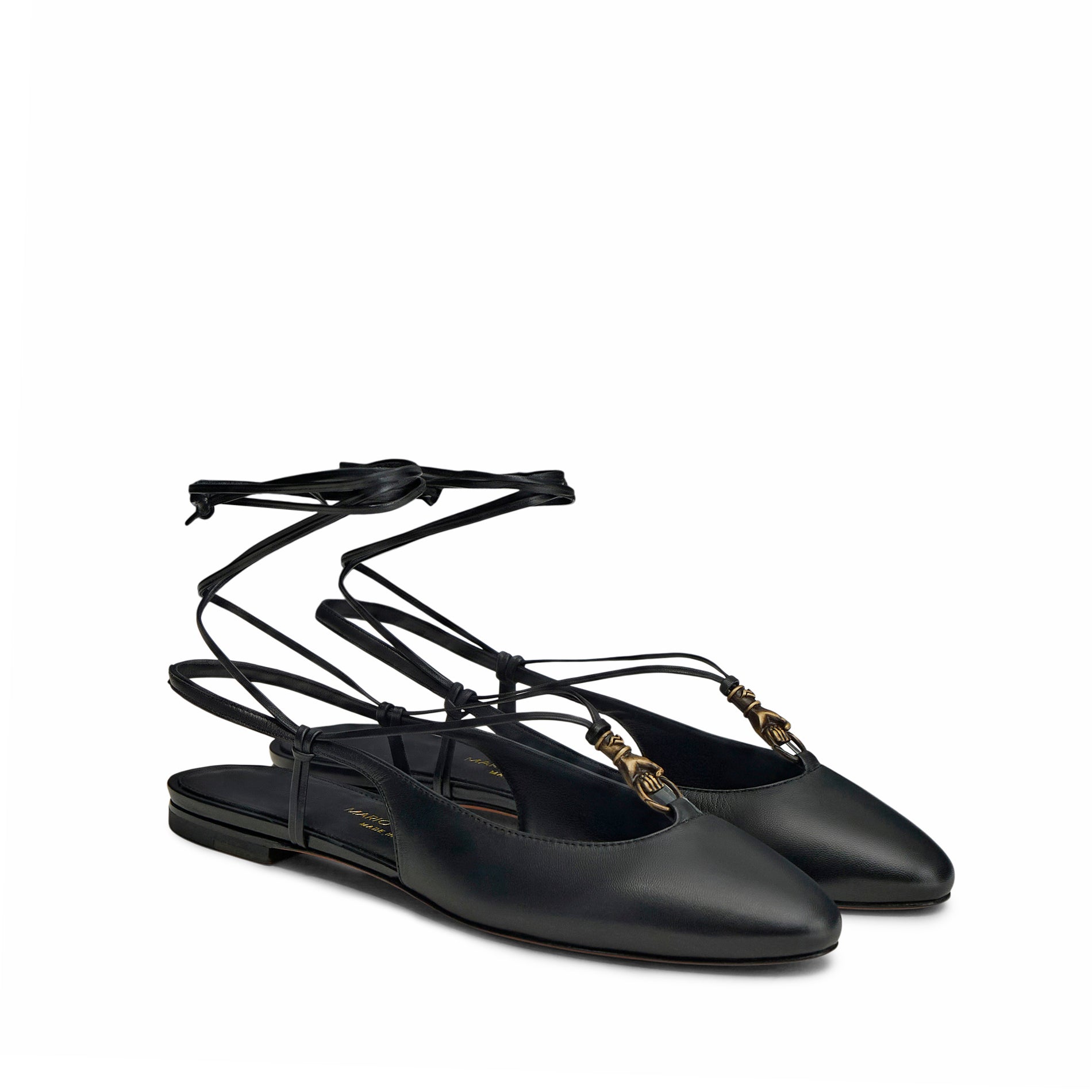 Mario Valentino elegant black slingback ballet flats in kidskin leather, adorned with an ethnic-inspired gold-tone embellishment and delicate lace-up ankle tie.