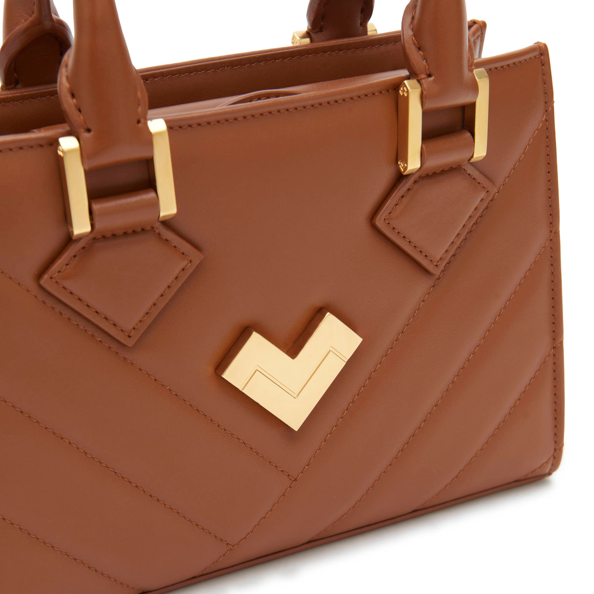 Brown leather bag close-up with gold hardware and matelassé detail, premium handbag. Made in Italy