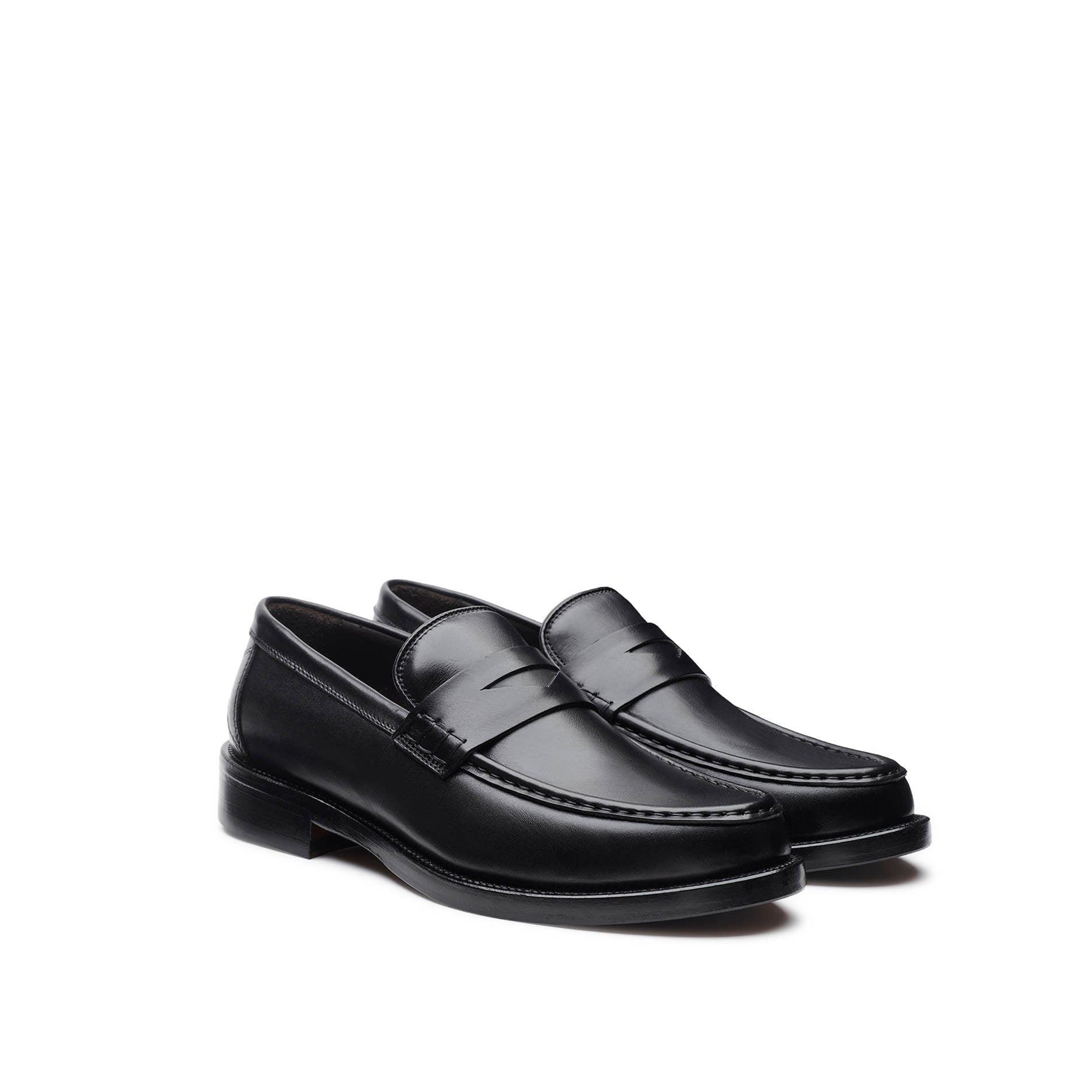 Three-quarter angle view of black calfskin loafer showing the apron seam and penny strap