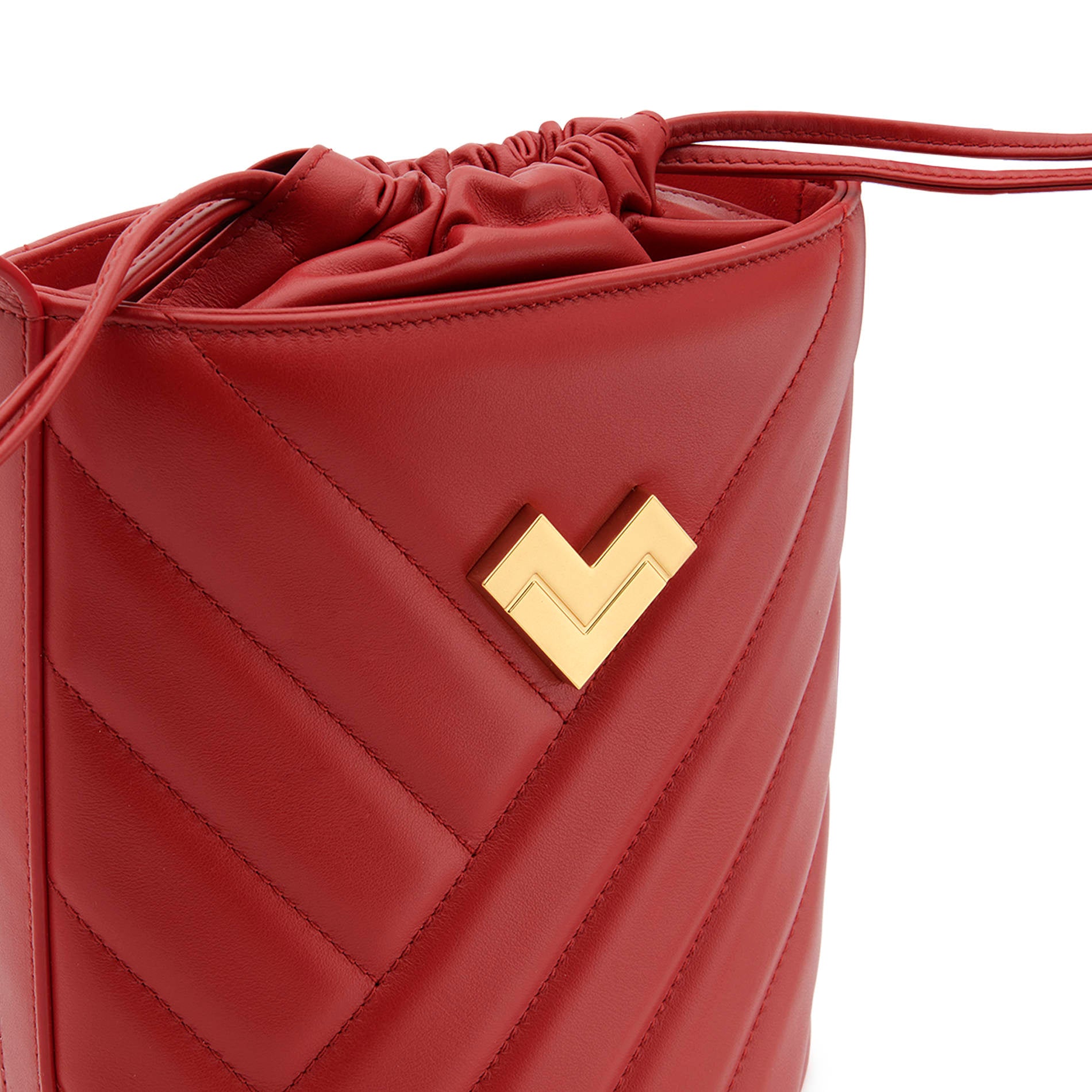 Red quilted leather crossbody bucket bag with gold logo, chevron stitching and leather drawstring detail.