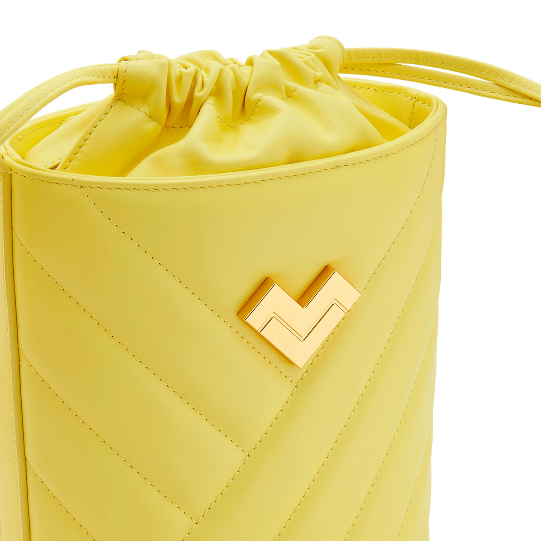 Yellow quilted leather crossbody bucket bag with chevron stitching, gold-tone logo and leather drawstring detail.