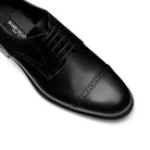 Close-up of black Oxford brogue shoes, perforated leather detail