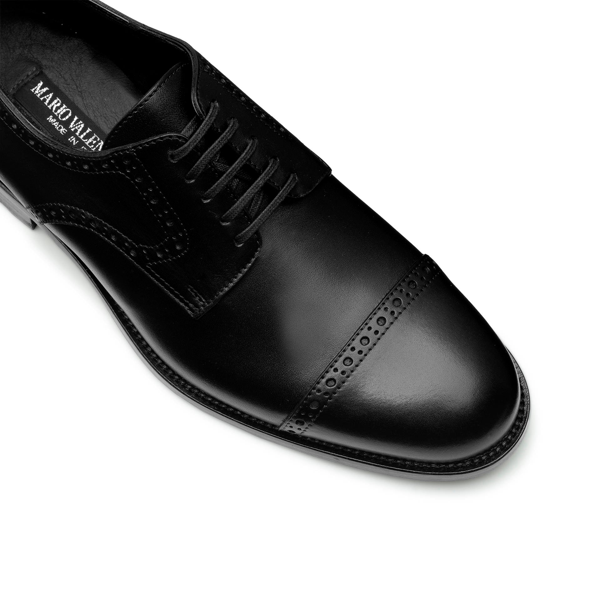 Close-up of black Oxford brogue shoes, perforated leather detail