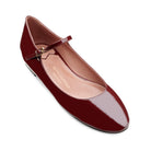 Detail of burgundy patent leather ballet flats with smooth glossy finish