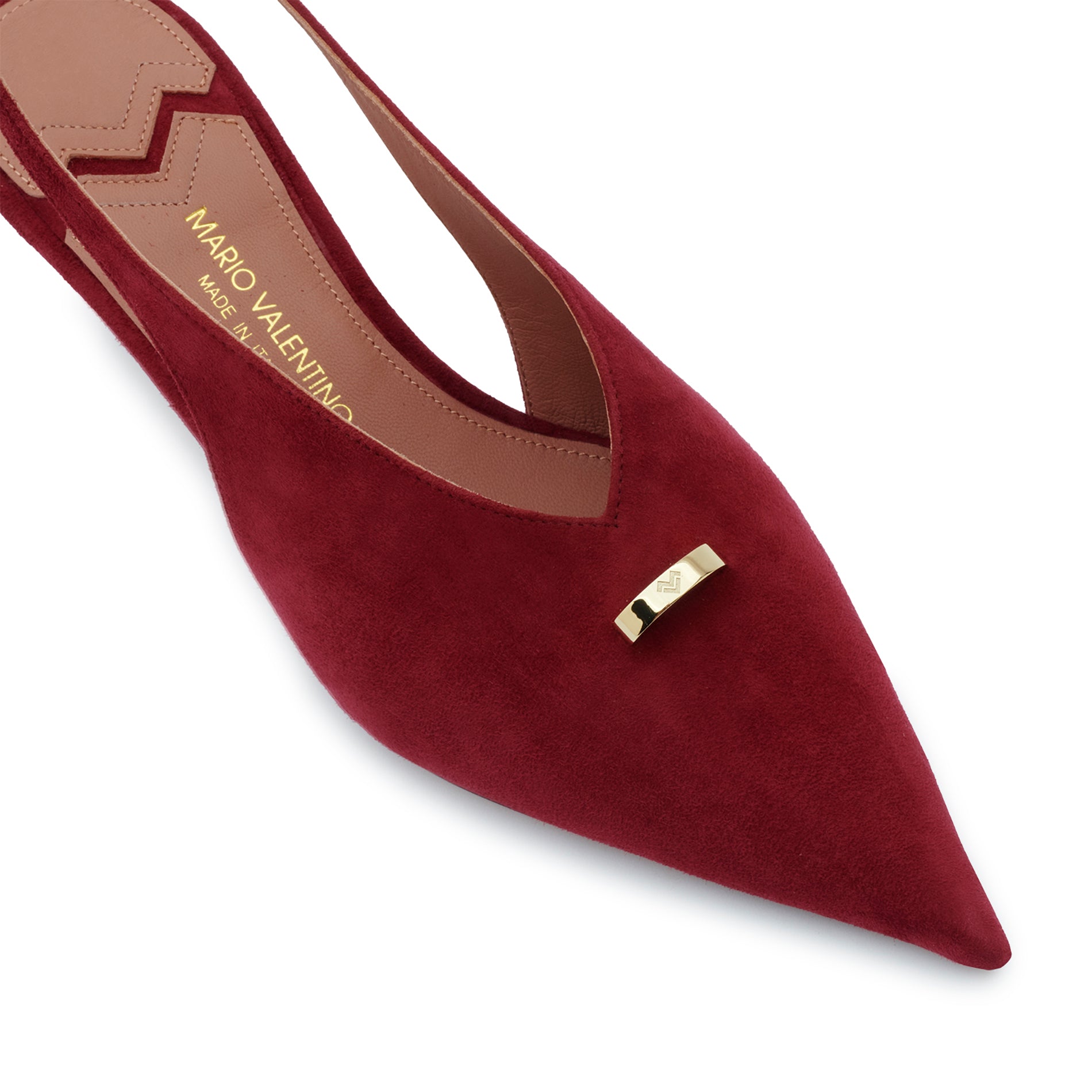 Close-up detail of Mario Valentino burgundy suede pumps featuring a polished gold-tone logo ring