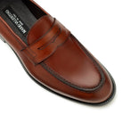 Close-up of light brown leather penny loafers, stitching and leather detail