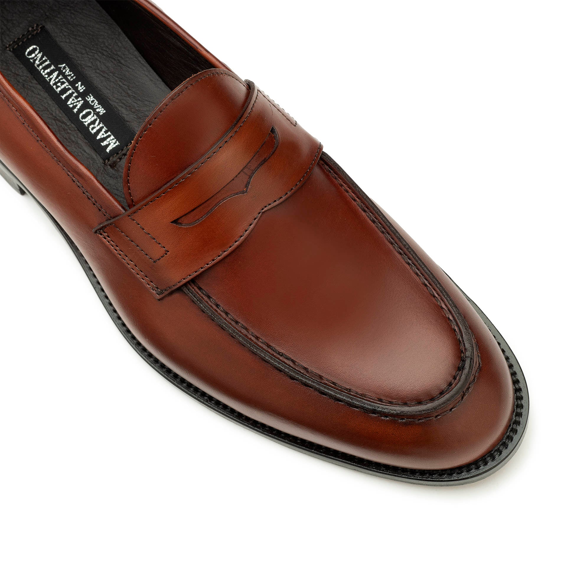 Close-up of light brown leather penny loafers, stitching and leather detail
