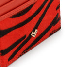Detail of Mario Valentino zebra-print calfhair with iconic MV metal logo and refined texture finish