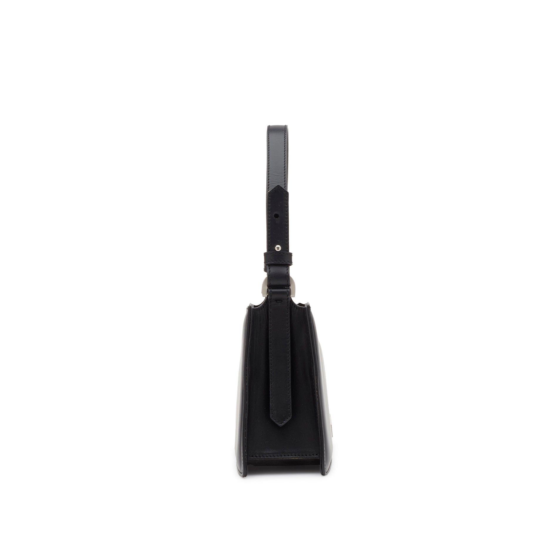 Side view of a structured black leather handbag with curved top edge, leather handle and detachable shoulder strap.
