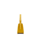 Yellow leather handbag with minimalist silhouette, magnetic closure and silver-tone details.