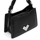 Close-up of the silver-tone MV logo on a black leather mini bag.