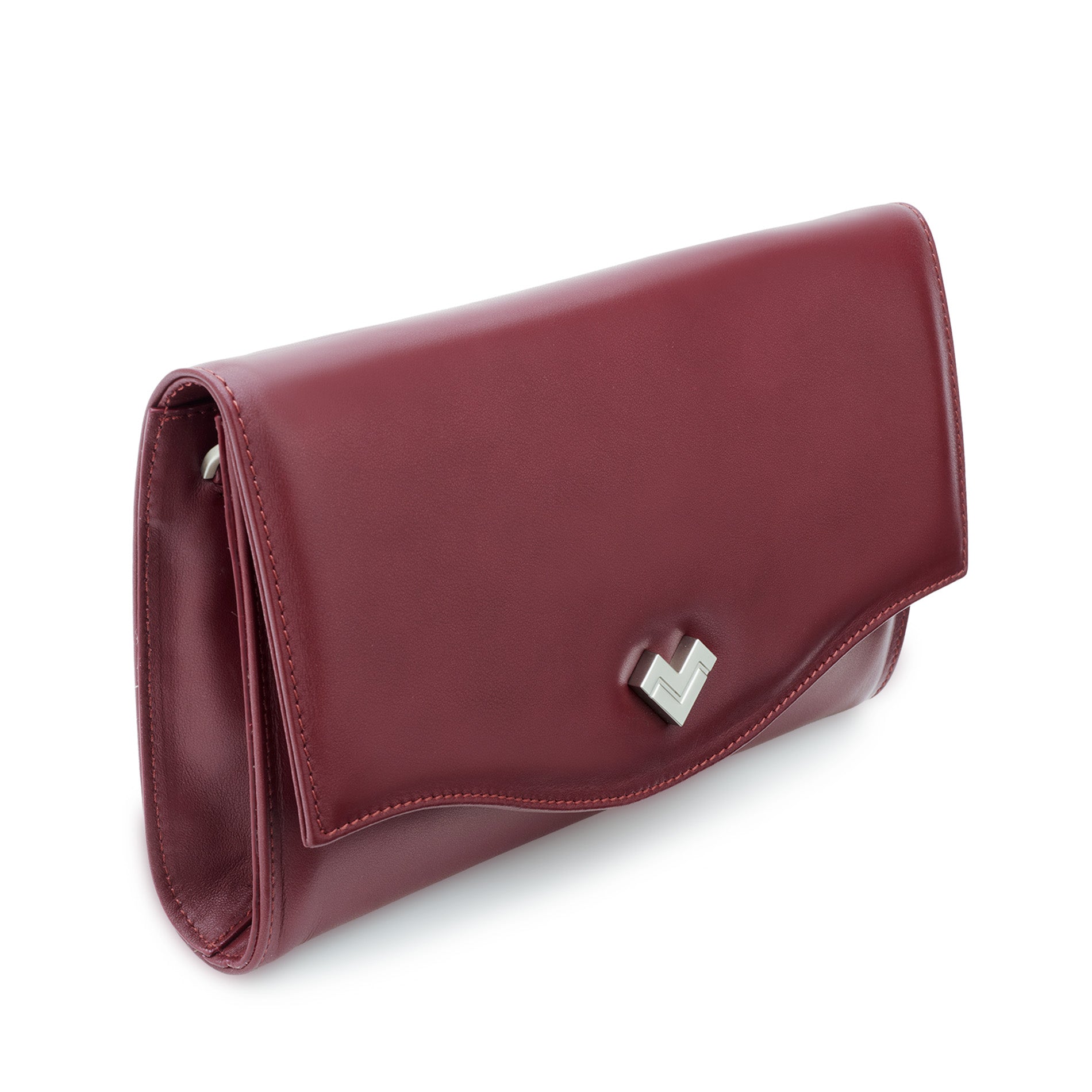 Close-up of the silver-tone MV logo detail on the curved flap of a burgundy leather clutch bag.