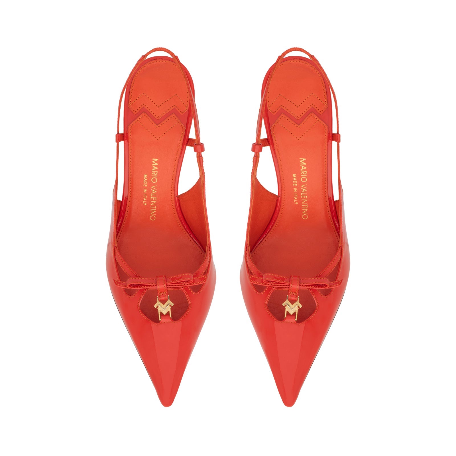 Pair of Mario Valentino lobster red slingback high heels featuring a glossy patent finish, pointed toe, and gold-tone logo charm on a delicate bow. Made in Italy
