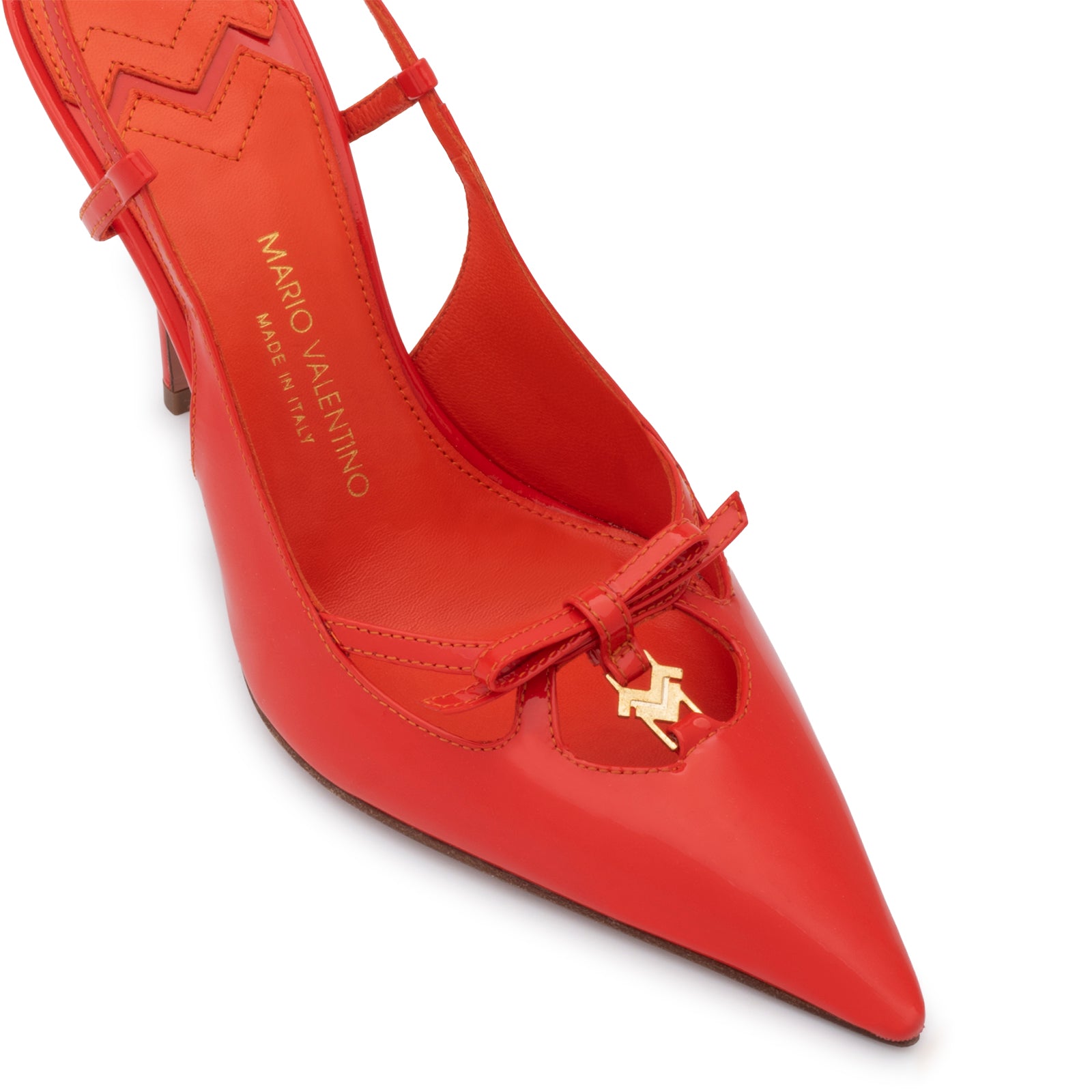 Mario Valentino slingback, Glossy patent finish, pointed toe, and gold-tone logo charm on a delicate bow. Made in Italy