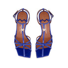 Aerial view of the Valerie T-bar sandal in vibrant bluette patent leather, showcasing the square toe and golden MV accessory.