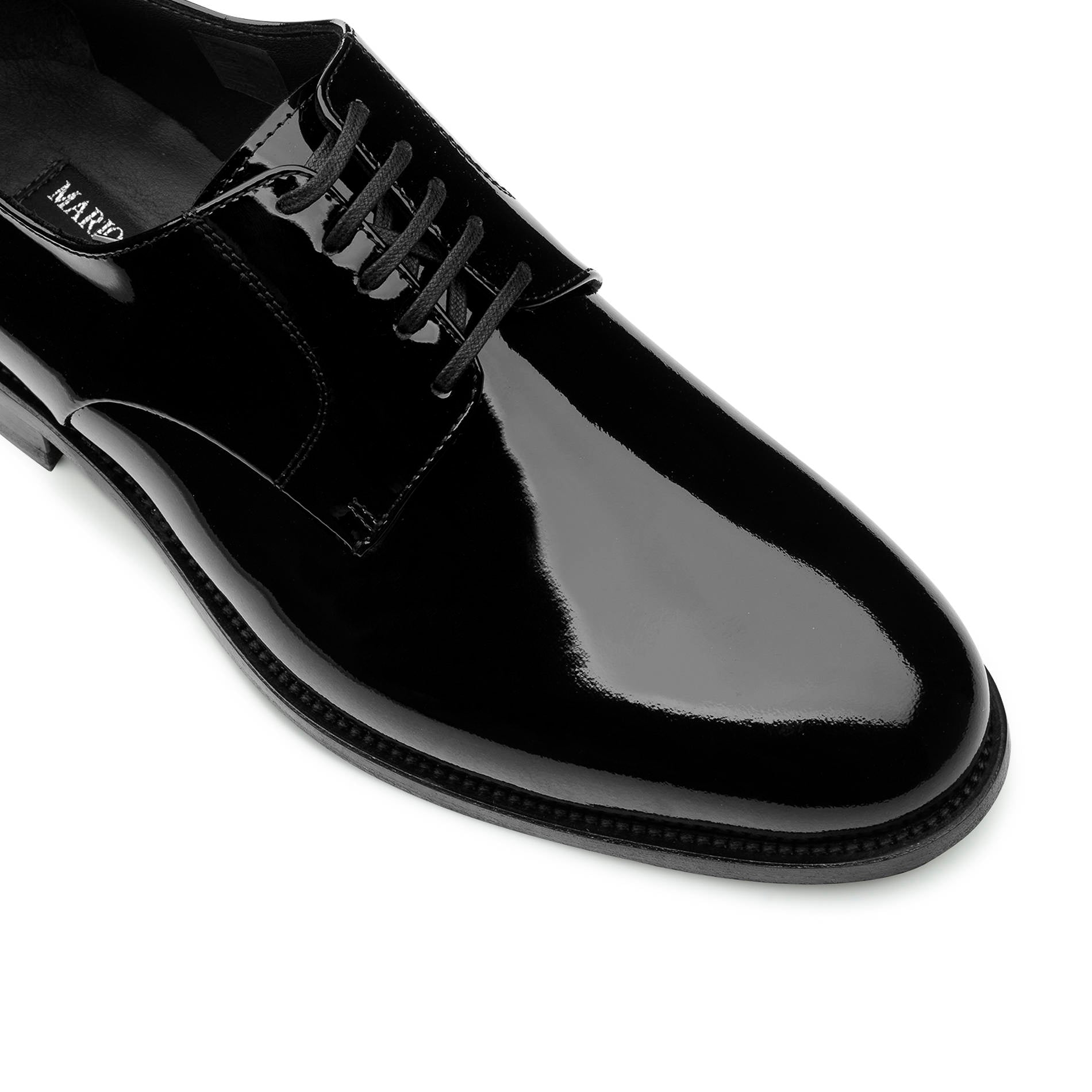Close-up of men’s black derby shoes, patent leather and lace detail