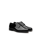 Black patent leather derby shoes with mirror-like lacquered upper, lace-up closure and leather sole, handcrafted in Italy — three-quarter view