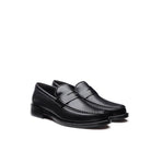 Three-quarter angle view of black calfskin loafer showing the apron seam and penny strap
