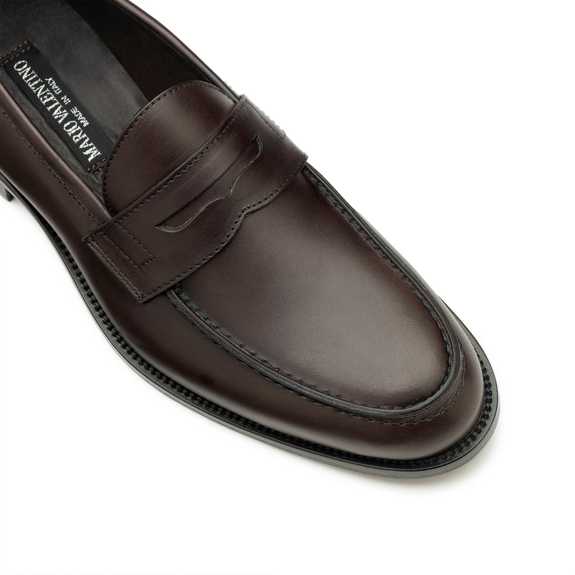 Close-up of brown leather penny loafers, stitching and leather detail