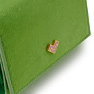Detail of Mario Valentino green calf hair leather wallet featuring a gold tone MV logo and a soft hair-on textured finish.