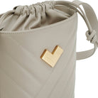 Grey quilted leather crossbody bucket bag with chevron stitching, gold-tone logo and leather drawstring detail.