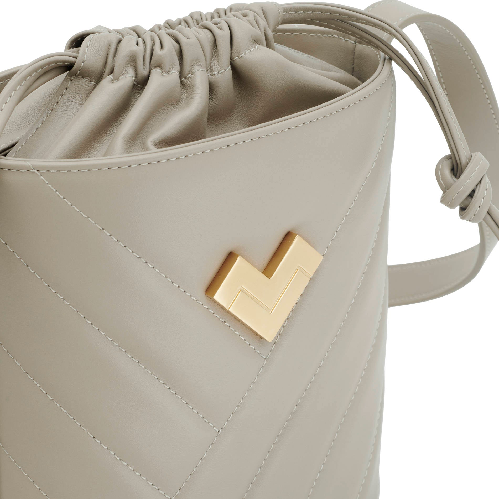 Grey quilted leather crossbody bucket bag with chevron stitching, gold-tone logo and leather drawstring detail.
