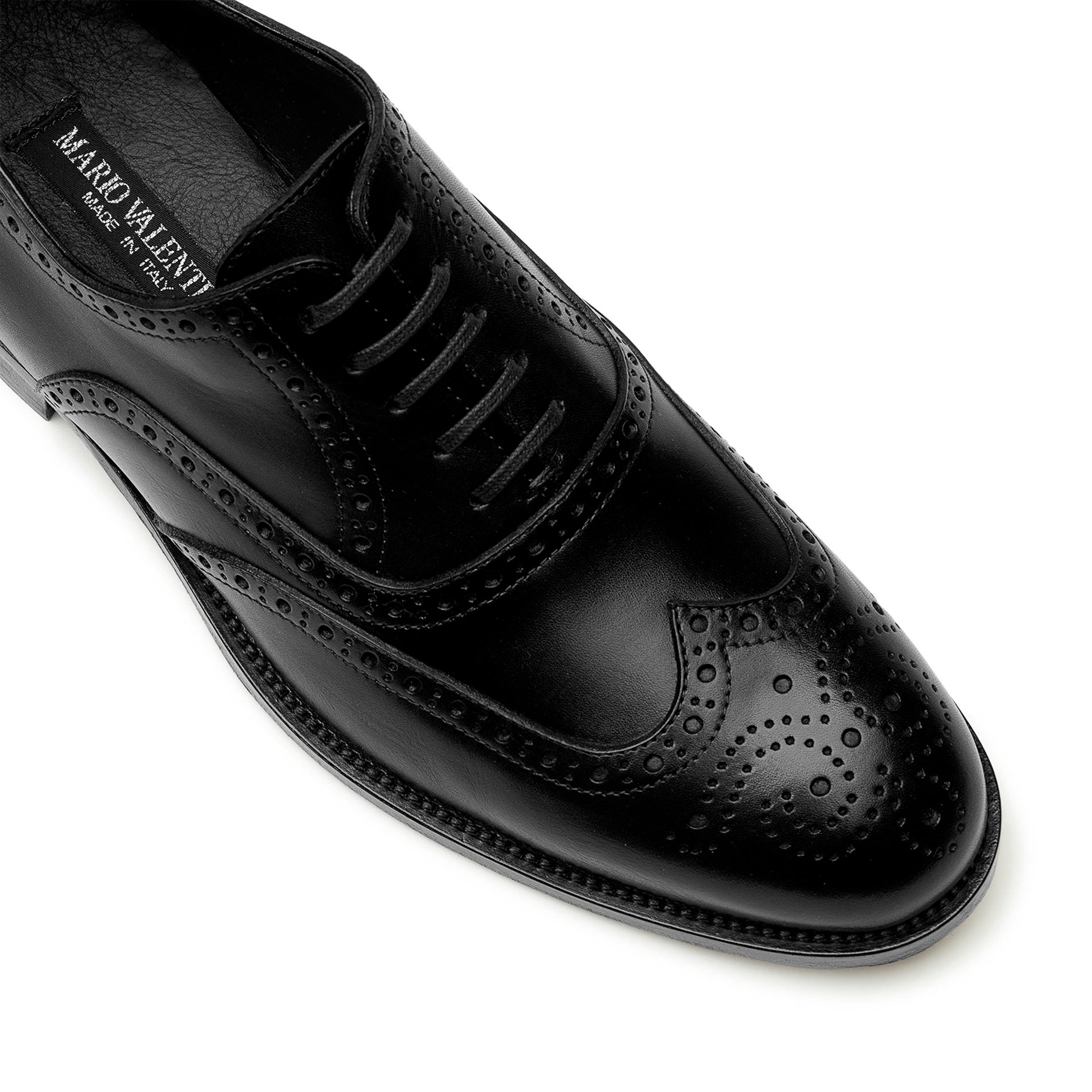 lose-up of black calfskin brogue Oxford shoes showing wingtip perforations and fine leather texture
