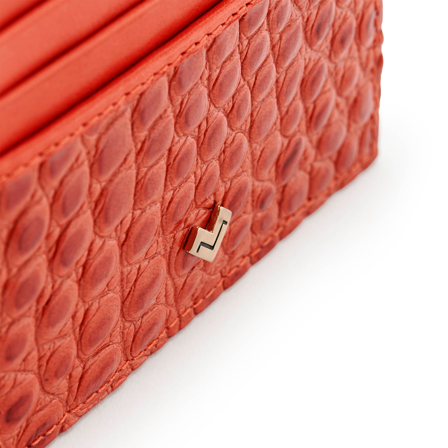 Detail of Mario Valentino red croc-embossed leather card holder featuring a gold-tone metal MV logo and a textured finish.