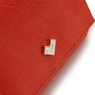 Detail of Mario Valentino red calf hair leather wallet featuring a gold and white tone MV logo and a soft hair-on textured finish.