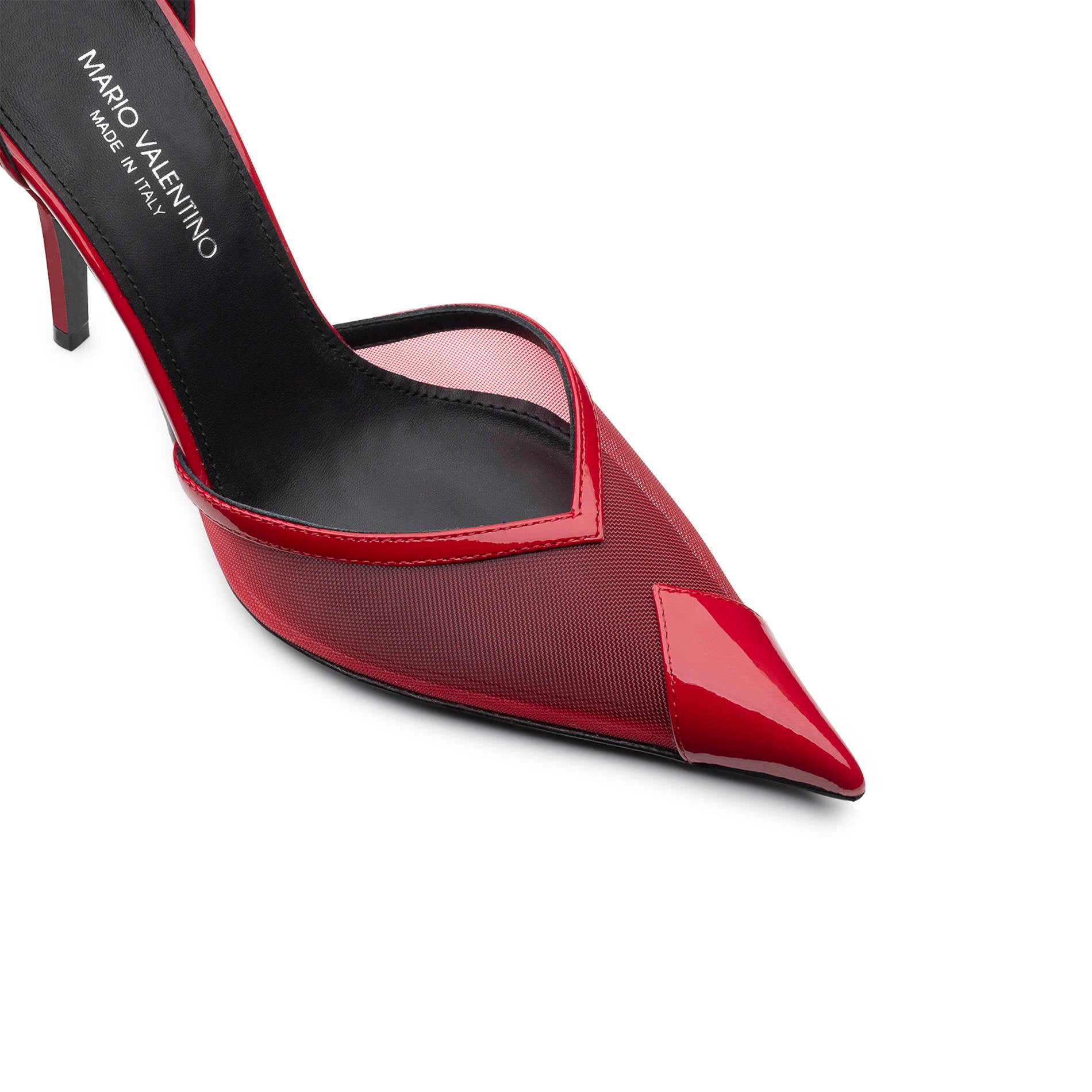 Detail of pointed toe red pumps in glossy patent leather with transparent mesh insert